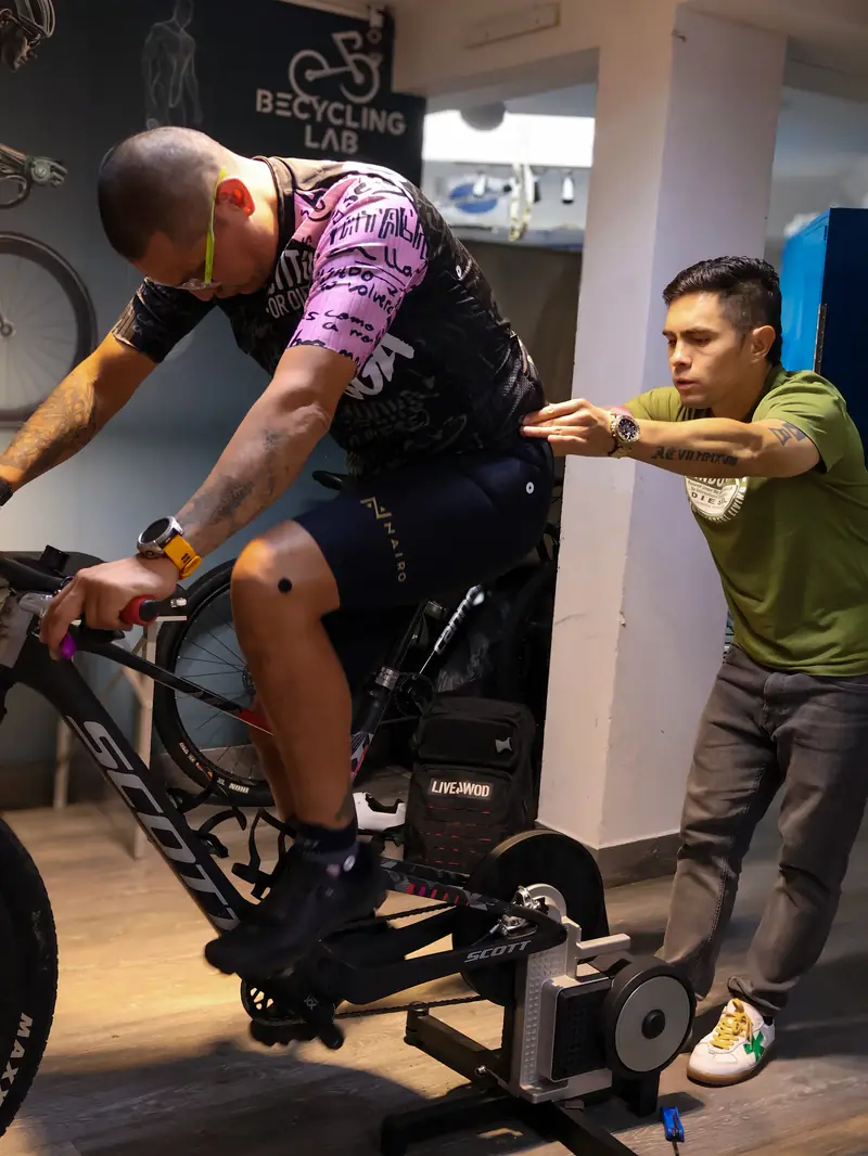 Carlos Jiménez corrigiendo la postura de un ciclista sobre el rodillo